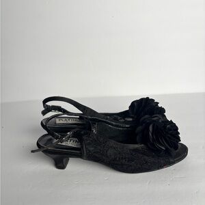 Black kitten heel with lace and flower detail w/ adjustable straps.